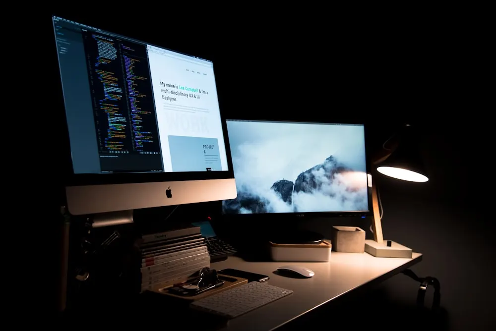 Desk with monitors showing website design and development work