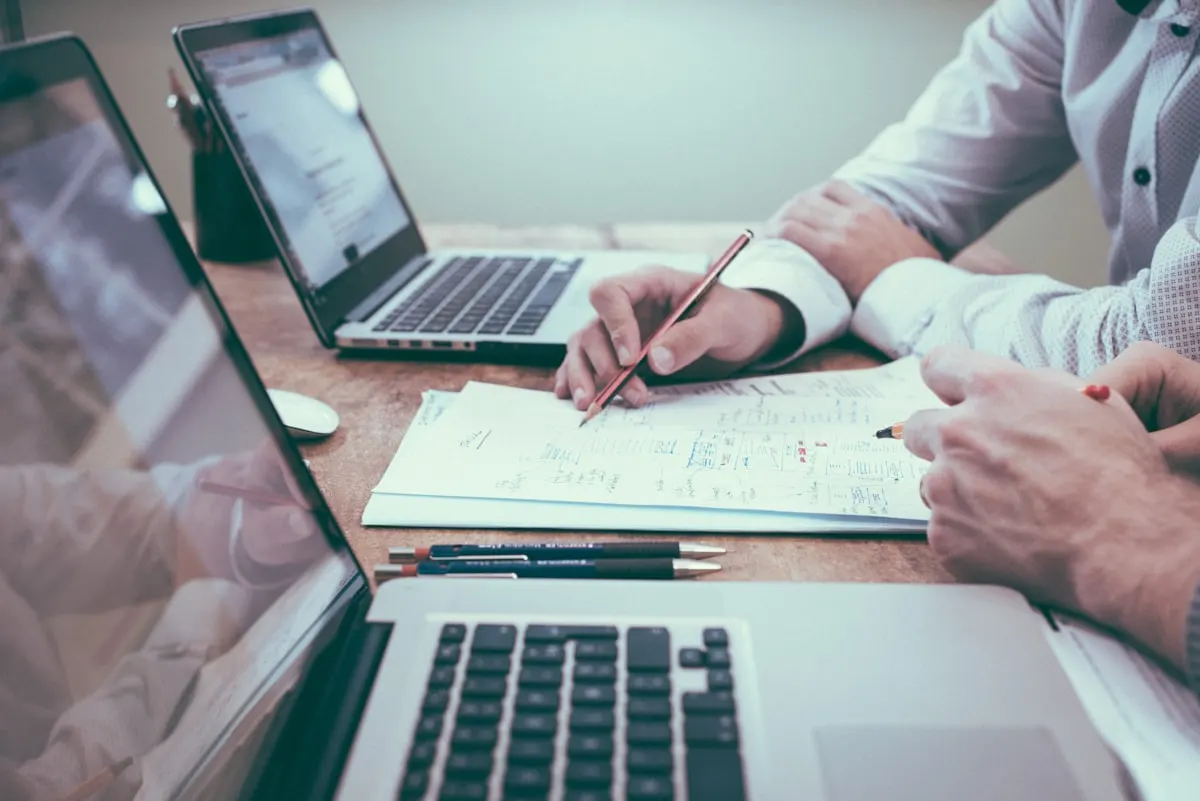Person planning workflows with charts and a laptop